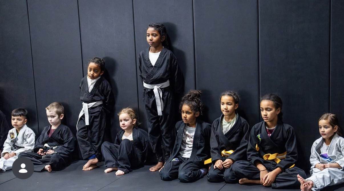 Kids jiu-jitsu class lined up along the wall at WDC BJJ Hyattsville