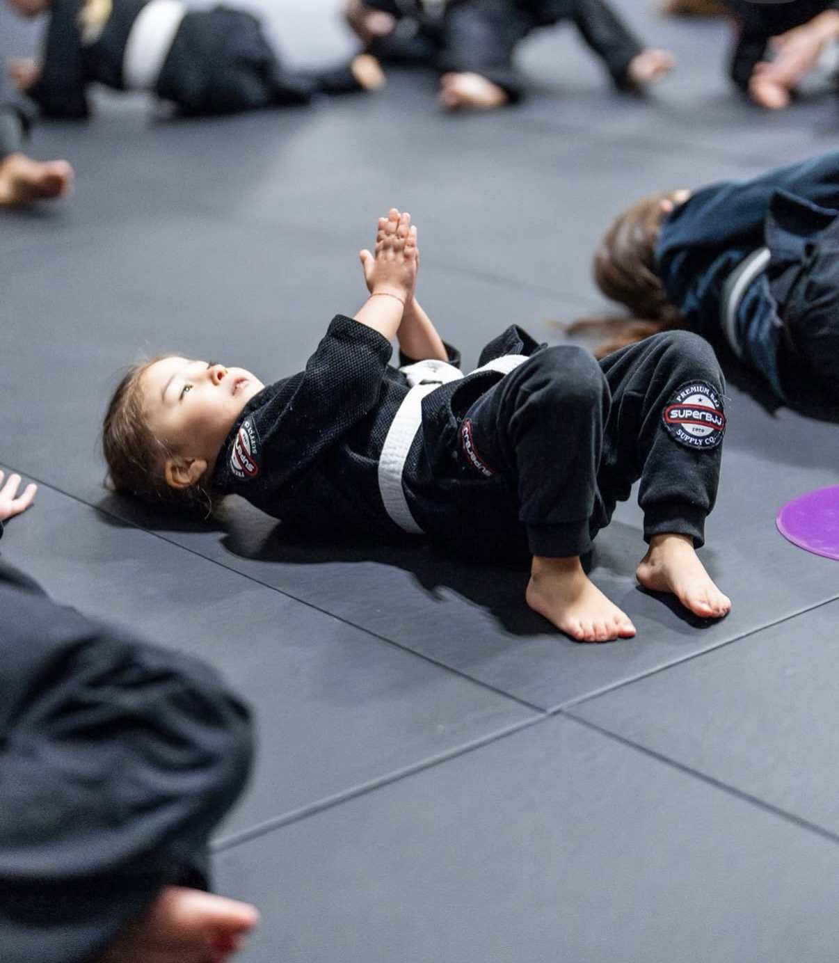 A young WDC BJJ Hyattsville student doing a warm-up drill on the mats